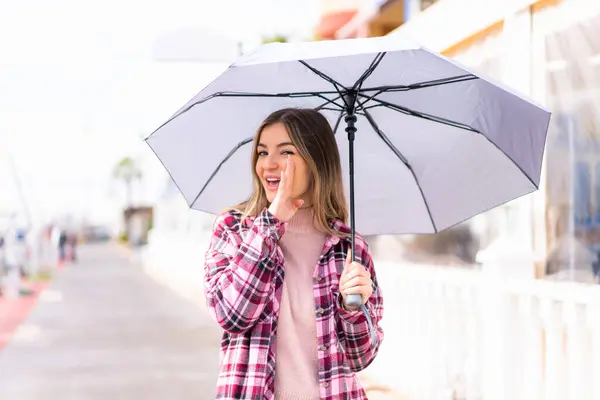 Jonge Mooie Roemeense Vrouw Met Een Paraplu Buitenlucht Fluisterend Iets — Stockfoto