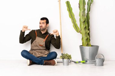 Bahçıvan kendini beğenmiş ve gururlu bir şekilde yerde oturuyor.