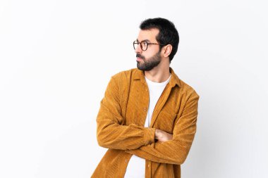 Beyaz arka plan portresinin üzerine kadife ceket giyen sakallı, beyaz saçlı yakışıklı bir adam.