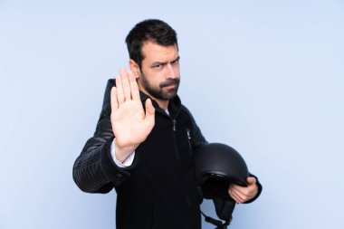 Motosiklet kasklı bir adam izole edilmiş arka planda durup jest yapıyor ve hayal kırıklığına uğruyor.