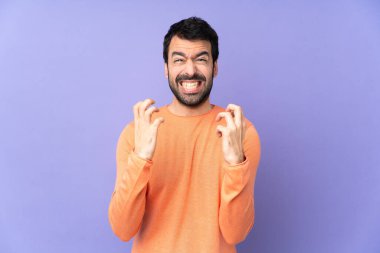 İzole edilmiş mor arka planda beyaz yakışıklı bir adam kötü bir durum yüzünden hayal kırıklığına uğradı.