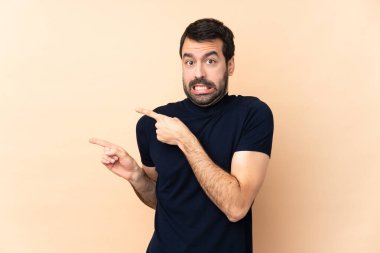 Kafkas yakışıklı adam izole edilmiş arka planda korkmuş ve kenarı işaret ediyor.