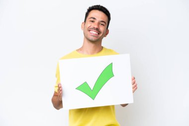 Young handsome man over isolated white background holding a placard with text Green check mark icon with happy expression