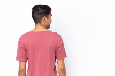 Genç yakışıklı adam izole edilmiş beyaz arka planda ve yan bakıyor.