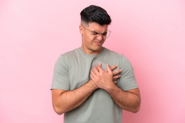 Pembe arka planda izole edilmiş beyaz tenli yakışıklı bir adamın kalbinde bir ağrı var.