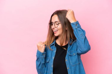 Pembe arka planda izole edilmiş beyaz bir kadın zaferi kutluyor.