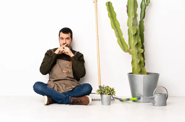 Jardinero Hombre Sentado Suelo Interiores Mostrando Signo Gesto Silencio —  Fotos de Stock