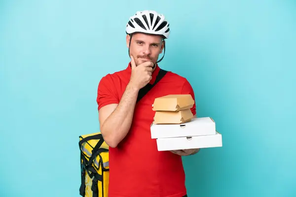 Młody Biały Mężczyzna Termalnym Plecakiem Trzymając Fast Food Izolowane Niebieskim — Zdjęcie stockowe