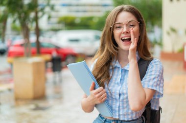 Açık havada ağzı açık bağıran kızıl saçlı genç bayan.