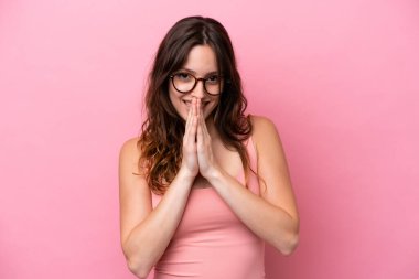 Pembe arka planda izole edilmiş genç beyaz kadın avuç içlerini bir arada tutuyor. İnsan bir şey ister.