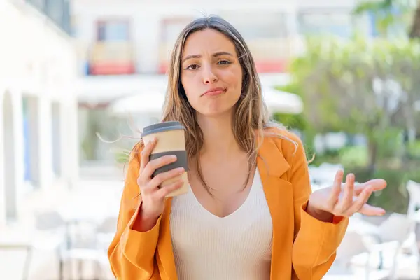 Young Pretty Woman Holding Take Away Coffee Outdoors Making Doubts — Stock Photo, Image