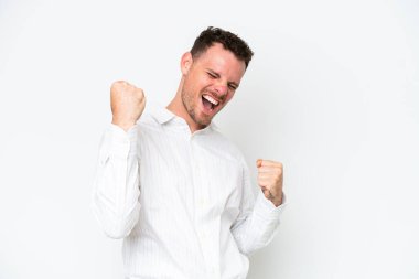 Beyaz arka planda izole edilmiş beyaz saçlı yakışıklı bir adam zaferi kutluyor.