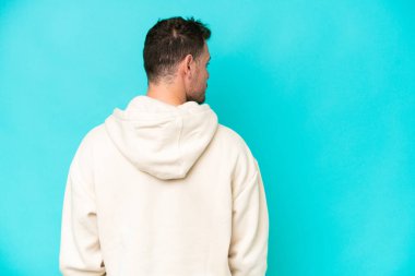 Beyaz tenli yakışıklı adam mavi arka planda izole edilmiş.