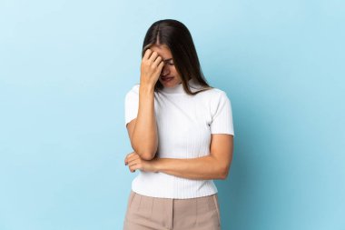 Genç Uruguaylı kadın mavi arka planda başağrısı ile izole edildi
