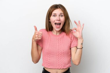 Beyaz arka planda izole edilmiş genç bir İngiliz kadın işaret ve baş parmak işareti gösteriyor.