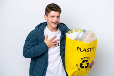 Beyaz arka planda geri dönüşüm yapmak için elinde plastik şişelerle dolu bir çanta tutan Rus ergen.