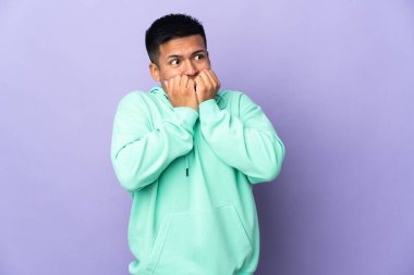 Genç Ekvador 'lu, mor arka planda izole edilmiş gergin ve korkmuş bir adam elleriyle suni teneffüs yapıyor.