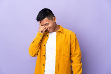 Genç Ekvadorlu adam, mor arka planda izole edilmiş gülüyor.