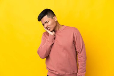 Genç Ekvadorlu adam sarı arka planda diş ağrısı ile izole edilmiş.