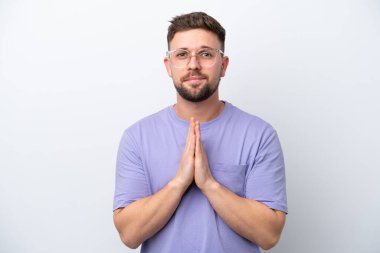 Beyaz arka planda izole genç beyaz adam avuç içlerini bir arada tutuyor. İnsan bir şey ister.