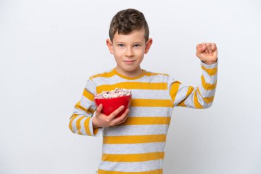 Beyaz arka planda izole edilmiş mısır gevreği kasesi tutan beyaz çocuk güçlü bir jest yapıyor.