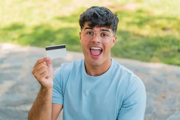Jeune Homme Hispanique Tenant Une Carte Crédit Extérieur Avec Une — Photo