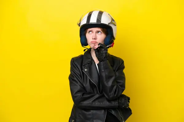 Junge Engländerin Mit Motorradhelm Auf Gelbem Hintergrund Hat Zweifel Und — Stockfoto