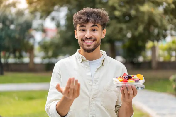 Young Arabian Handsome Man Holding Bowl Fruit Outdoors Inviting Come — Stock Photo, Image