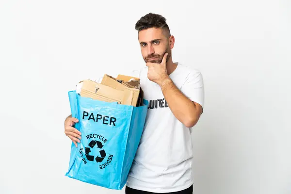 白い背景の思考で隔離されたリサイクルするために紙でいっぱいのリサイクル袋を持っている白人男性 — ストック写真
