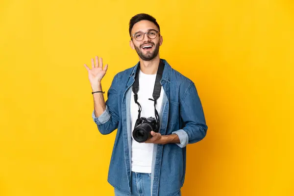 Junges Fotografenmädchen Auf Gelbem Hintergrund Salutiert Mit Fröhlicher Miene Der Stockfoto