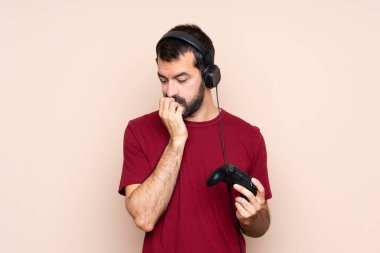 İzole edilmiş duvarın üzerinde video oyunu kontrolörüyle oynayan adamın şüpheleri var