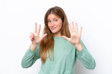 Beyaz arka planda izole edilmiş genç beyaz kadın parmaklarıyla sekizi sayıyor.