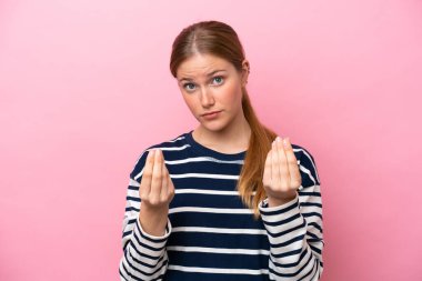 Pembe arka planda izole edilmiş genç beyaz kadın para hareketi yapıyor ama mahvoluyor.