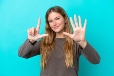 Young blonde woman isolated on blue background counting seven with fingers clipart