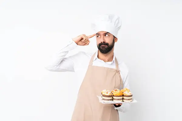 Junger Mann Hält Muffin Kuchen Über Isoliertem Weißen Hintergrund Und — Stockfoto