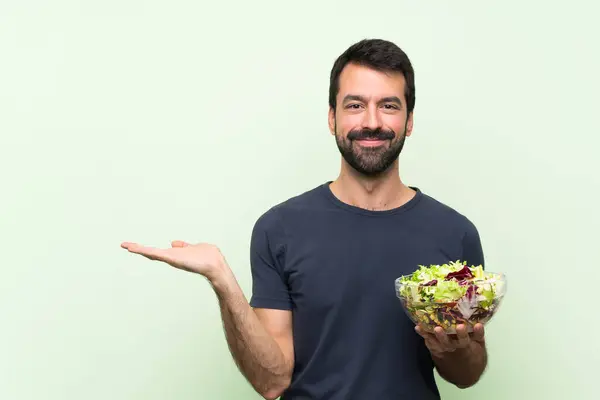 Young Handsome Man Salad Isolated Green Wall Holding Copyspace Imaginary Stock Picture