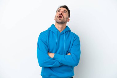 Beyaz arka planda izole edilmiş genç beyaz adam yukarı bakıyor ve şaşırmış bir ifadeyle