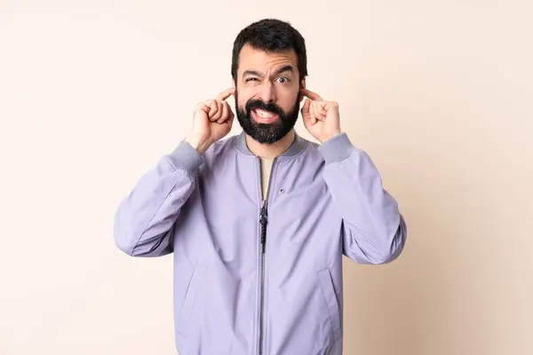 Kaukasischer Mann Mit Bart Trägt Eine Jacke Über Isoliertem Hintergrund lizenzfreie Stockbilder