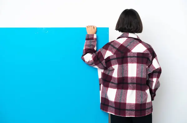 Junge Mischlingshündin Mit Einem Großen Blauen Plakat Auf Weißem Hintergrund lizenzfreie Stockfotos