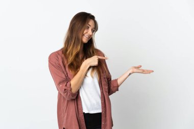 Beyaz arka planda izole edilmiş genç İrlandalı kadın bir ilan vermek için avucunun içinde hayali bir mekan tutuyor.