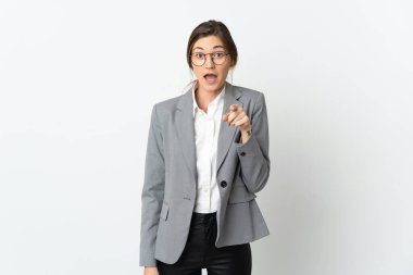 Beyaz arka planda izole edilmiş İrlandalı kadın şaşırmış ve ön tarafı işaret ediyor