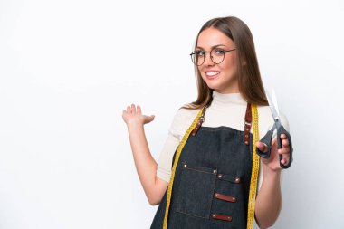 Young seamstress woman isolated on white background extending hands to the side for inviting to come