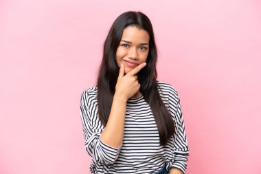 Pembe arka planda soyutlanmış genç Kolombiyalı kadın