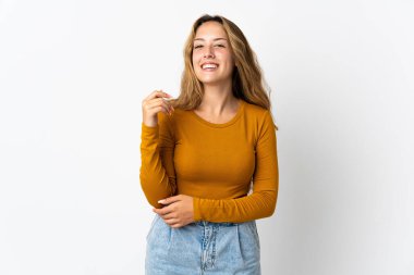 Genç sarışın kadın mavi arka planda yalnız gülüyor.