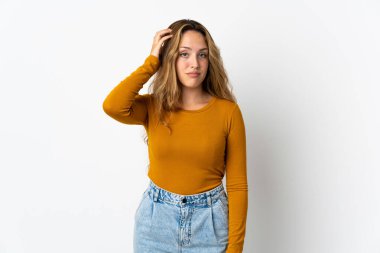 Mavi arka planda izole edilmiş genç sarışın bir kadın. Hayal kırıklığı ifadesi var ve anlamıyor.