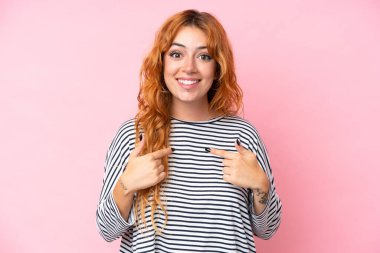 Pembe arka planda yalıtılmış beyaz bir kadın. Şaşırtıcı bir yüz ifadesi var.