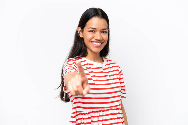 Молодая колумбийская женщина выделяется на белом фоне, показывая и показывая пальцем