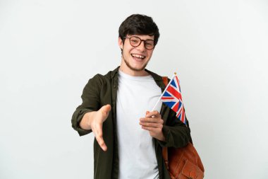 Beyaz arka planda izole edilmiş bir Birleşik Krallık bayrağı tutan genç bir Rus adam iyi bir anlaşma için el sıkışıyor.