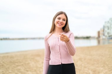 Genç, güzel, sarışın bir kadın kendine güvenen bir ifadeyle seni işaret ediyor.