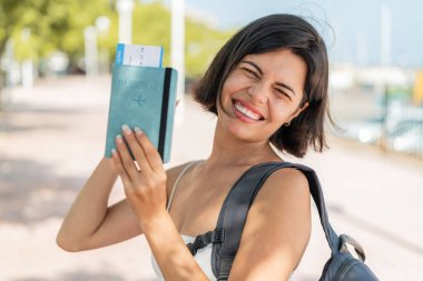 Açık havada elinde pasaport tutan ve zaferi kutlayan genç, güzel Bulgar kadın.